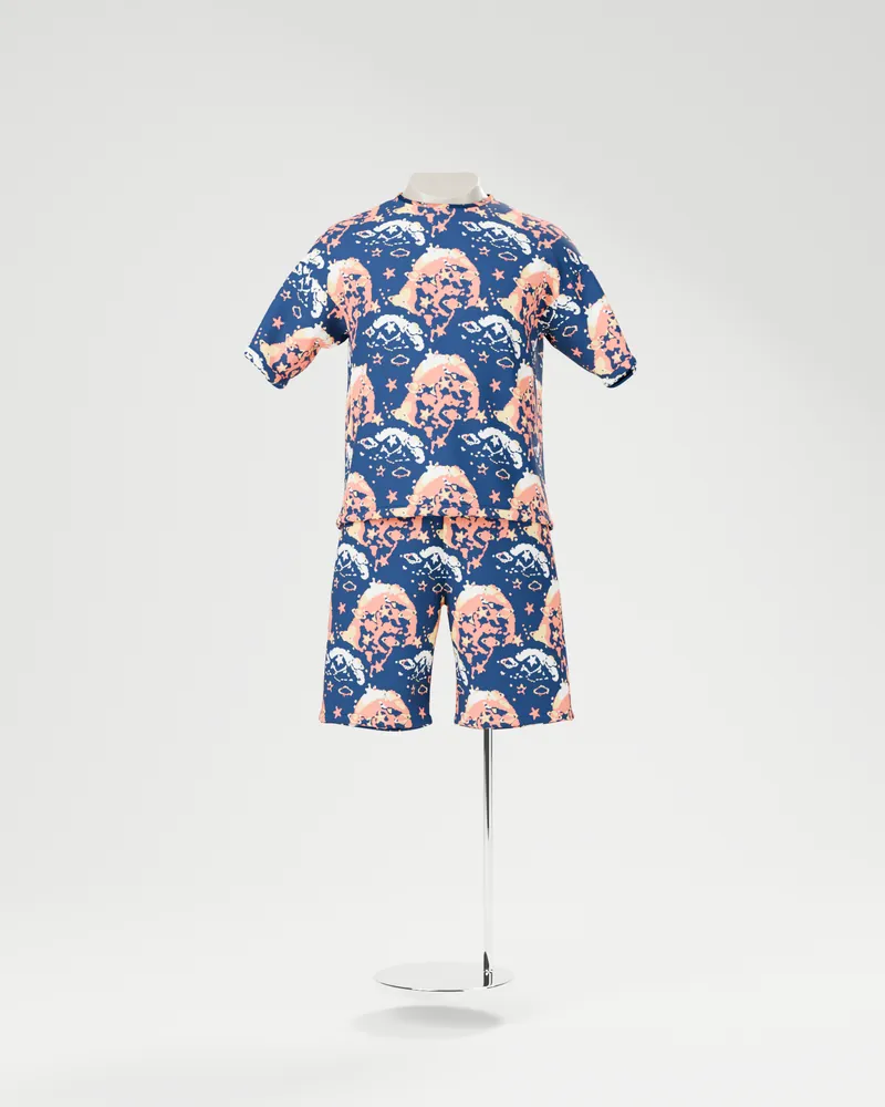 Lo stesso manichino con maglietta e pantaloncini stampati con un pattern blu notte, corallo e crema
